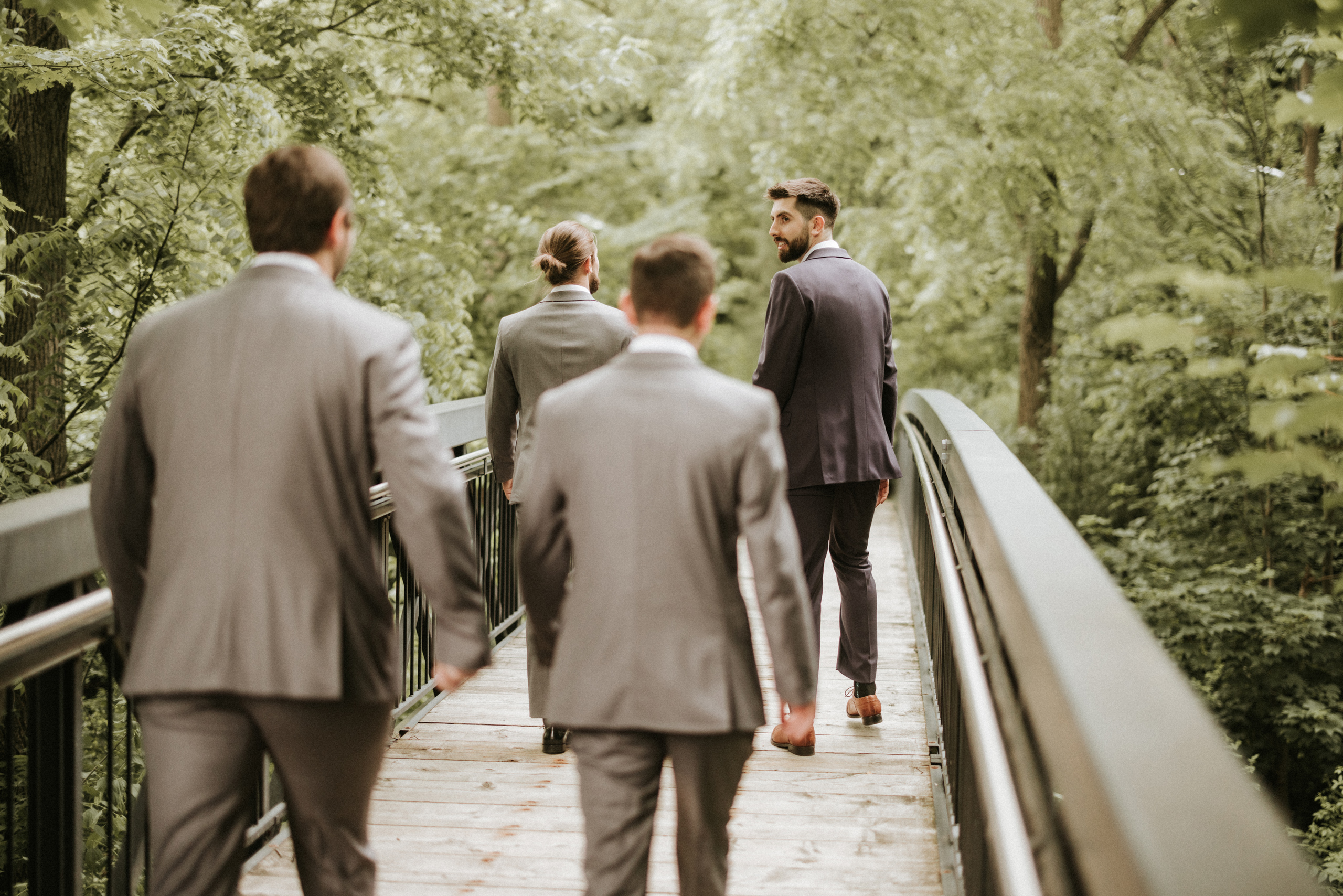 groomsmen walking bridge ancaster mill summer wedding