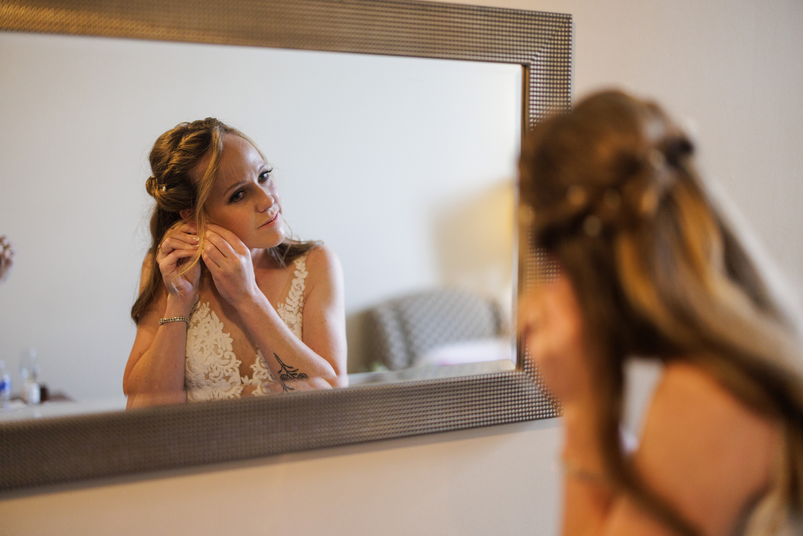 bride put in earrings mirror inn on the twenty